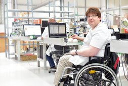 Mann sitzt in seinem Rollstuhl am Arbeitsplatz | © iStockphoto